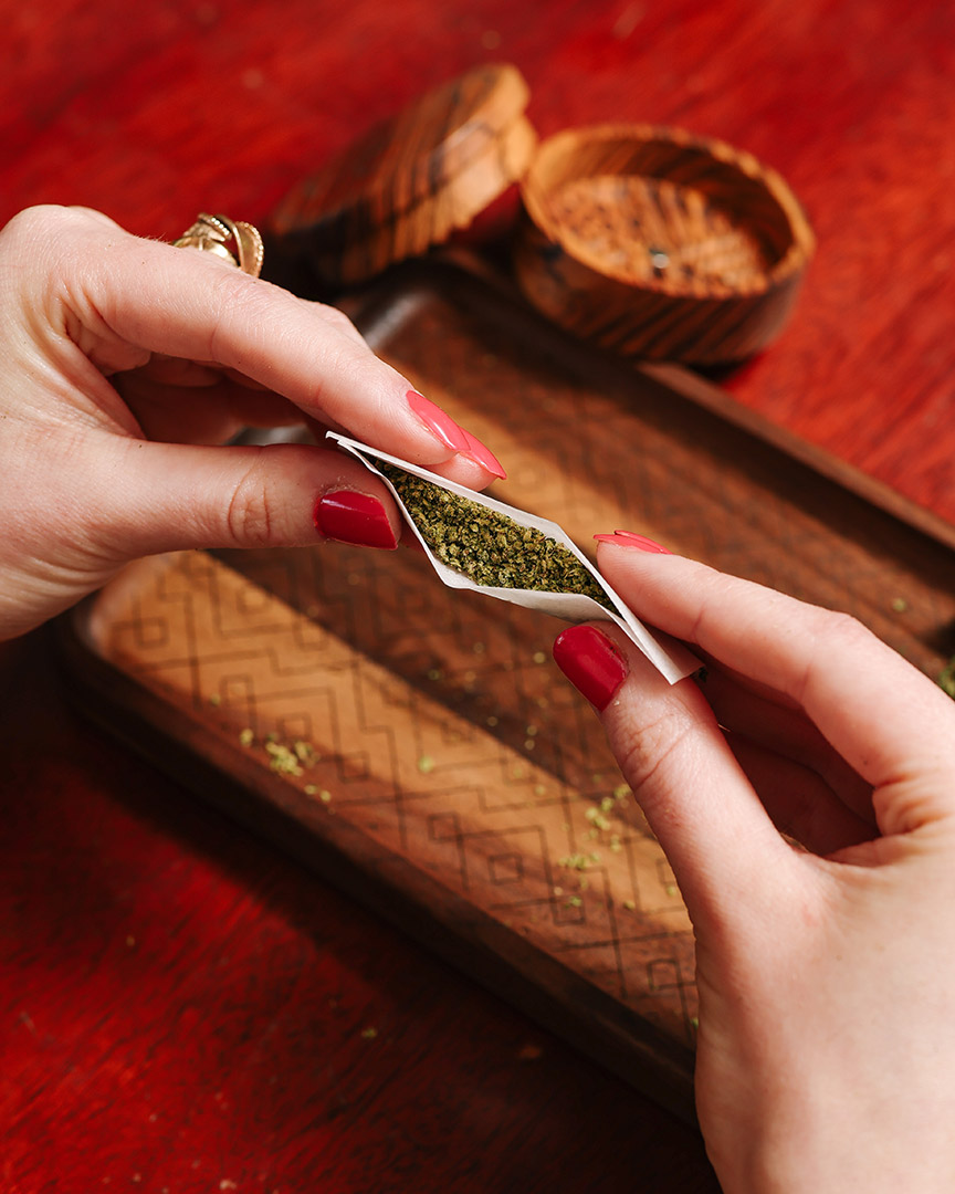 woman's hands rolling a Homage cannabis joint